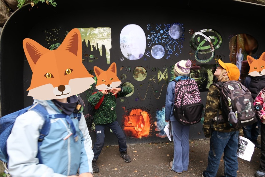 en gruppe mennesker som står ved siden av en vegg med tegneseriefigurer