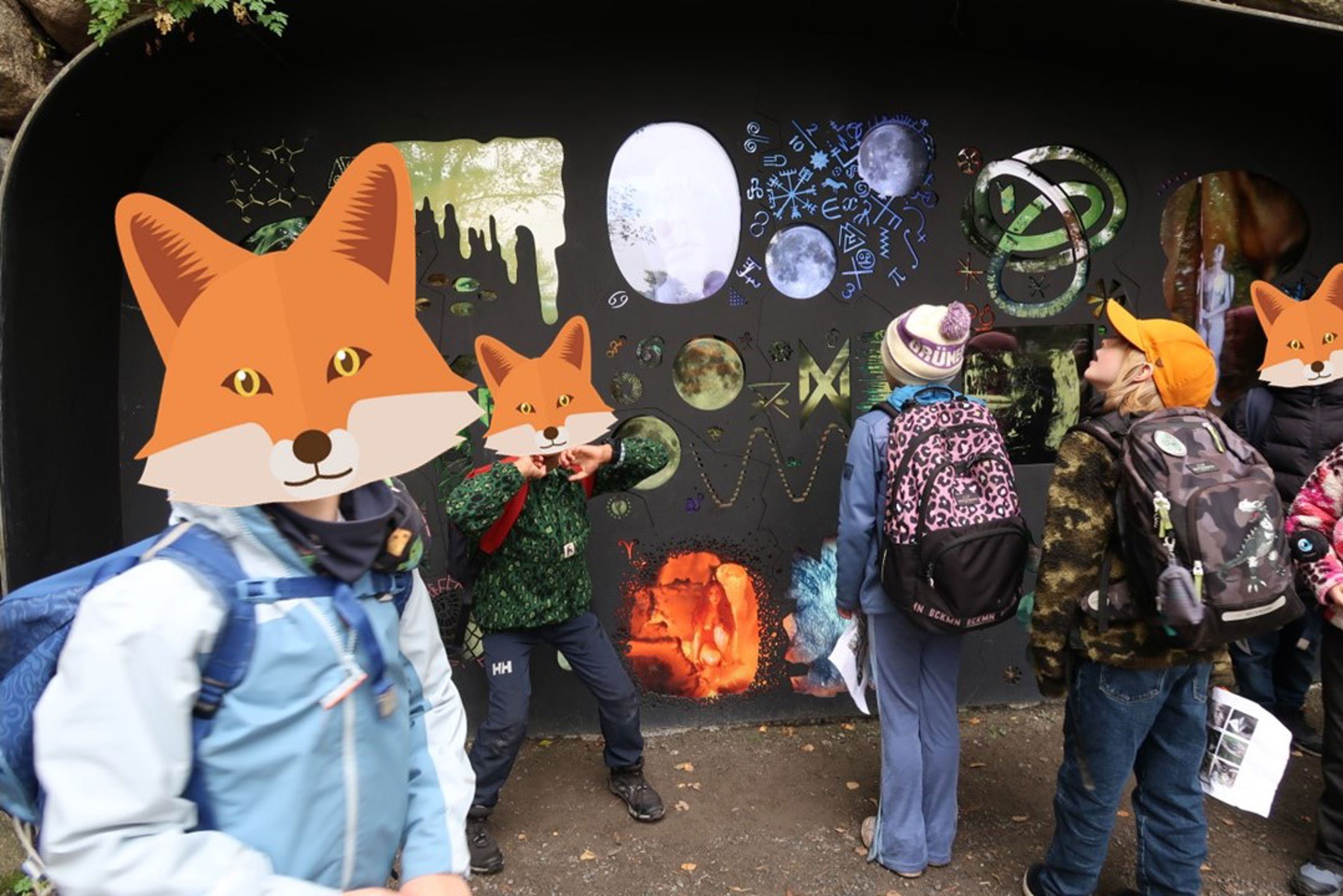 en gruppe mennesker som står ved siden av en vegg med tegneseriefigurer