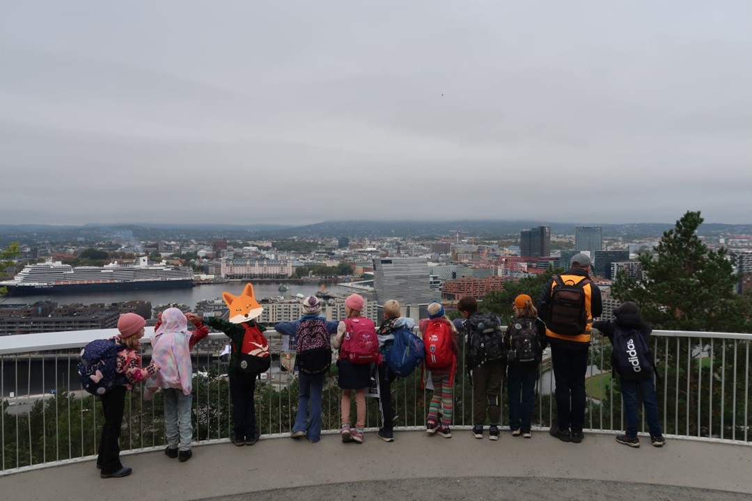 en gruppe mennesker som står på en balkong med utsikt over en by