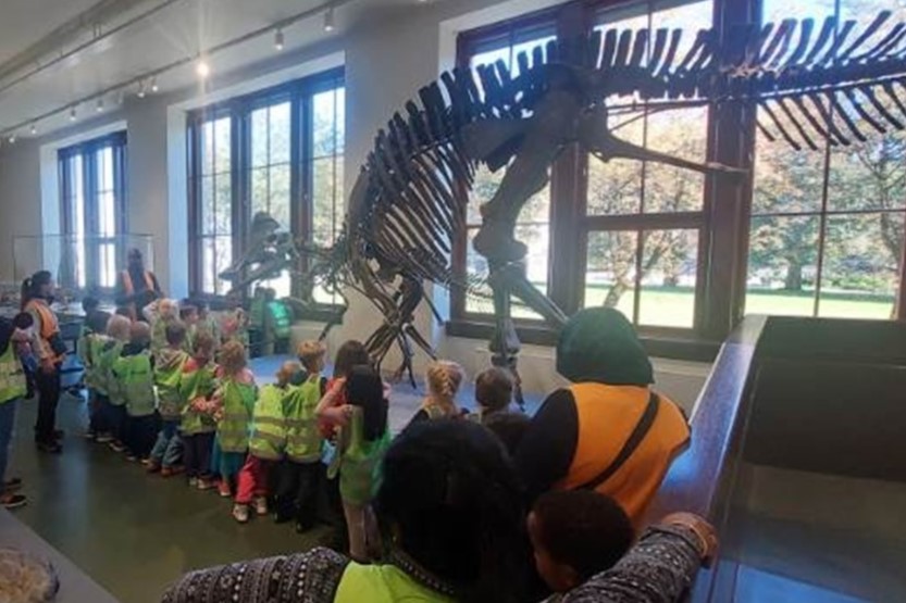 En gruppe mennesker som ser på en dinosaur