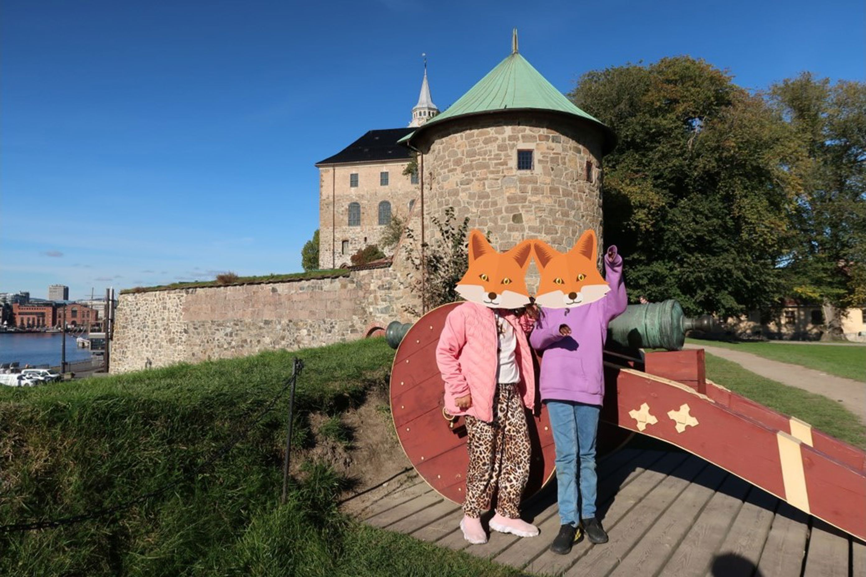en gruppe mennesker i klær som står på en steinmur ved en bygning