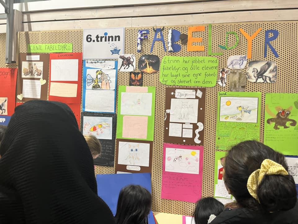 En gruppe mennesker som ser på en tavle med tegninger på