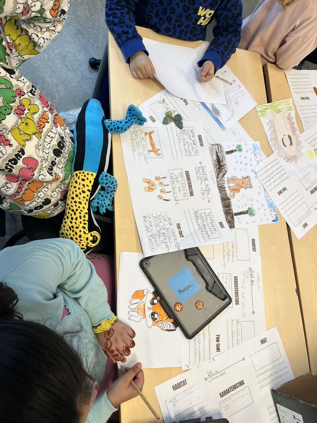 en gruppe mennesker som sitter ved et bord med papirer og en telefon