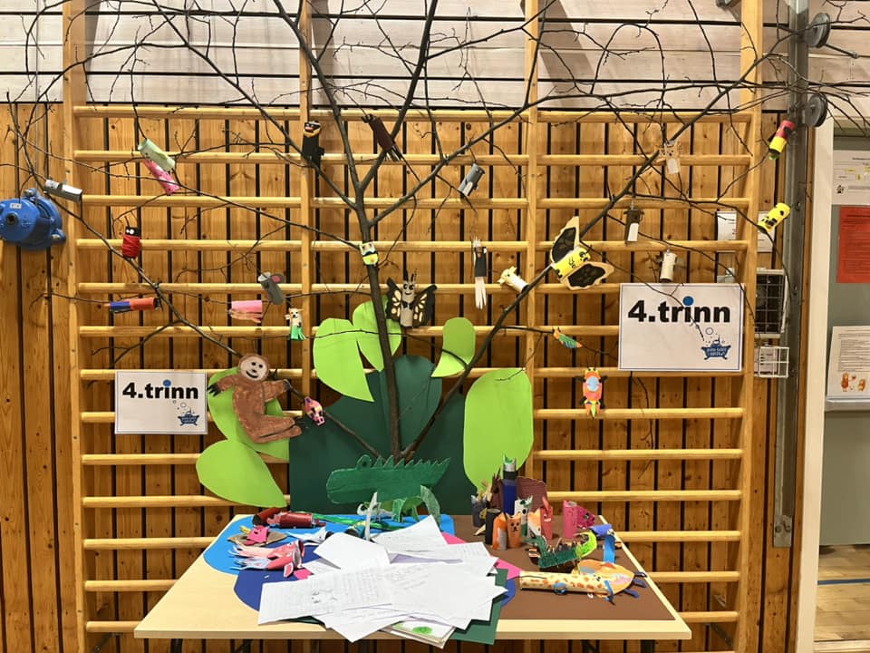 et tre gjerde med et tre og et skilt på den