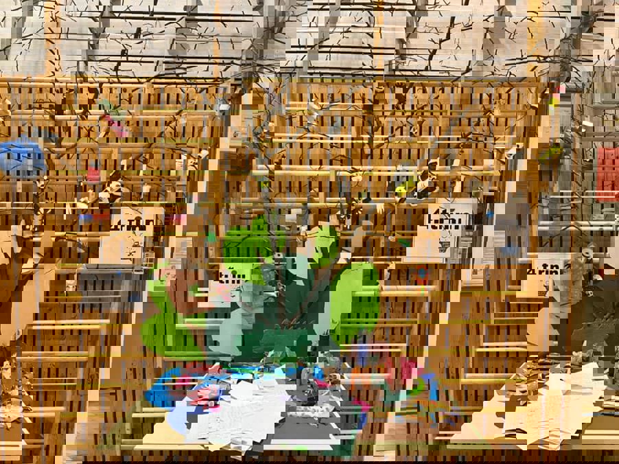 et tre gjerde med et tre og et skilt på den